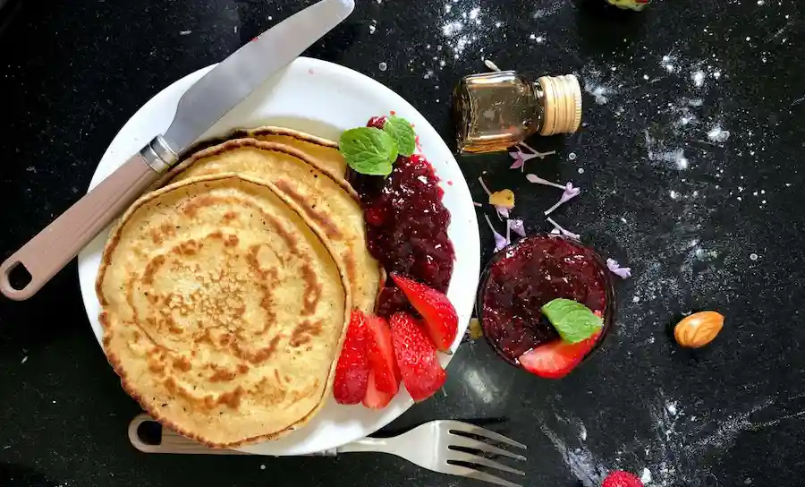 Panquecas com geleia e morangos frescos fatiados